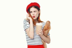 Mujer francés en un rojo sombrero con un pan de café y un azul antecedentes foto