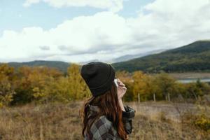 mujer en un médico máscara y tapas en naturaleza en otoño en el bosque foto