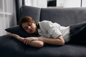 woman with closed eyes resting lying on the sofa photo