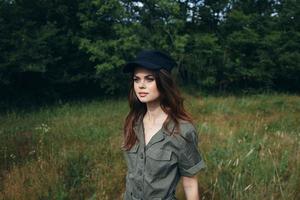 mujer en el bosque mujer en verde traje negro gorra lado ver estilo de vida Fresco aire foto