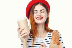 Frenchwoman in a red hat With a loaf of coffee and a blue background photo