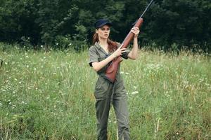 Woman on outdoor holding a gun in his hands fresh air travel hunting photo