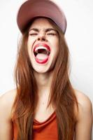 Woman with a cap with closed eyes opens his mouth wide emotions on her head red lips photo