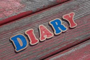 word diary made of wooden letters on old shabby board photo