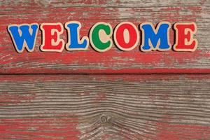 word welcome made of wooden letters on old wooden board photo