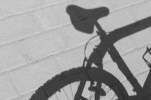 black and white photo of shadow of back part of bicycle