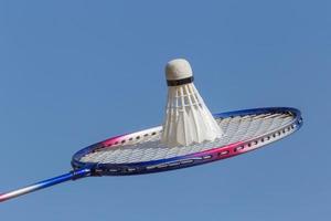 cerca arriba de bádminton raqueta con volante en contra azul cielo foto