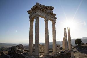 Ruins of the Temple of Trajan the ancient site of Pergamum-Pergamon. Izmir, Turkey. Ancient city columns with the sun in the background. photo