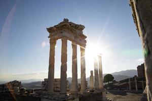 Ruins of the Temple of Trajan the ancient site of Pergamum-Pergamon. Izmir, Turkey. Ancient city columns with the sun in the background. photo