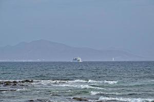 sea landscape with the ocean and a view of the Spanish island of De Lobos with a ship in the background photo