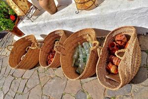 glass items in close-up in straw baskets in front of a souvenir shop photo