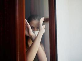 a woman looks out of the window with her arms crossed in front of her photo