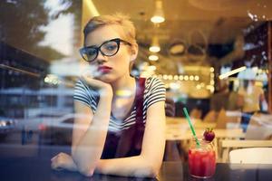 mujer sentado en un café cóctel mirando fuera el ventana ocio estilo de vida foto