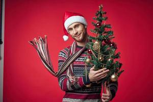 man with christmas tree in hands toys decoration holiday new year photo