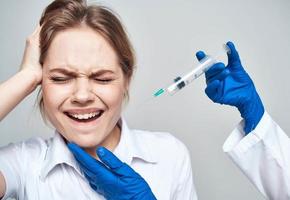 Scared woman and syringe in the hands of the doctor shock emotions model photo