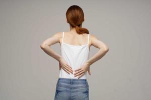 disgruntled woman pain symptoms in the joints arthritis light background photo