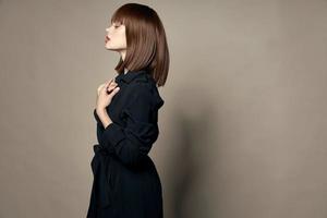 Side view of a beautiful woman in a black coat makeup photo