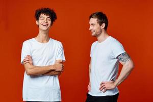 funny two men in white t-shirts on a red background friendship photo