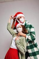 Man smothers woman Christmas hats Merry Christmas medical holiday masks photo