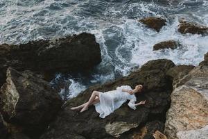 hermosa mujer en blanco Boda vestir en mar apuntalar mojado pelo naturaleza paisaje foto