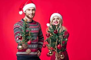 man and woman with christmas trees in hands toys decoration christmas fun photo