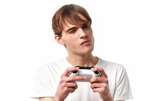 chico en un blanco camiseta con un palanca de mando en su manos juegos entretenimiento pasatiempo foto
