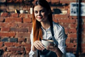 mujer con un taza de café cerca el mesa camarero Servicio trabajo profesionales foto