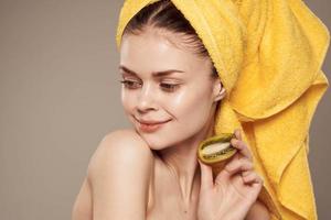 cheerful woman with a towel on her head and hands skin care naked shoulders beige background photo