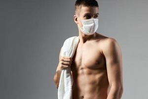 cute man pumped up body medical mask safety gym isolated background photo