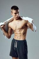 athletic man with towel in hands pumped up press gym photo