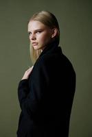 An elegant lady looks to the side posing in isolation on a green background photo