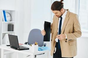 man in beige jacket in the office with documents lifestyle photo