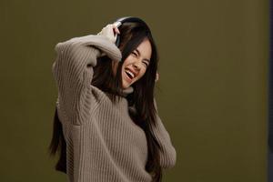 portrait woman in a sweater listening to music with headphones fun isolated background photo