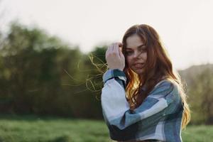 Portrait of a woman with a beautiful smile and straight teeth on a summer day in the sunset with flying curly hair photo