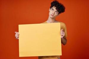 Cheerful guy with curly hair poster studio cropped view photo