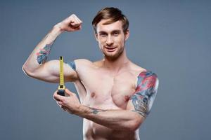 tattooed man muscular bodybuilder Fitness gray background photo