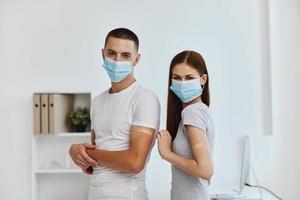 young couple in medical masks adhesive plasters on hands lakhtin vaccine passport photo