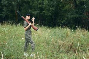 Woman on nature Side view of woman with arms on shoulder gesturing with hand photo