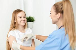 mujer médico dando un niña un inyección en el brazo vacunación foto