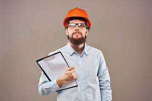 A man in orange paint with documents in hands building an industrial business photo