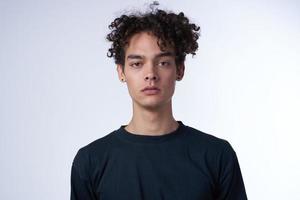 man in a black sweater on a light background curly hair portrait photo