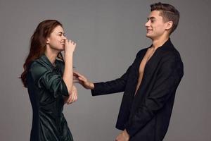 Happy woman looks at an attractive man in a jacket on a naked torso photo