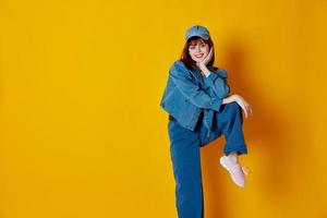 Portrait of a charming lady denim clothing fashion posing cap yellow background unaltered photo