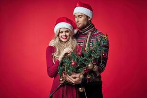 man and woman in new year clothes together holiday gifts red background photo