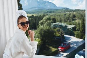 Portrait woman in a bathrobe in the morning on the balcony admiring nature unaltered photo
