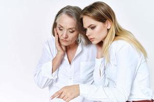 cute grandmother and granddaughter studio posing fun light background photo