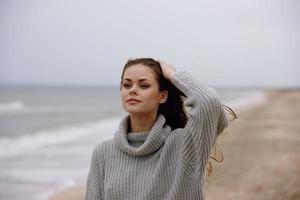 hermosa mujer rojo pelo en un suéter por el Oceano relajación concepto foto