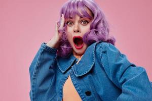 Pretty young female wavy purple hair blue jacket emotions fun pink background unaltered photo