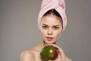 Woman holds Mango in hands bare shoulders clean skin vitamins health photo