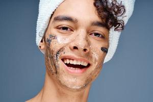 Cheerful guy with a towel on his head cosmetics on the face clean skin photo